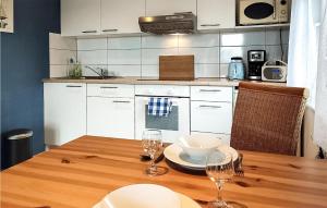cocina con mesa de madera y 2 copas de vino en Nice Home In Heidesee With House Sea View, en Heidesee