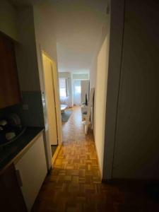 a hallway leading to a room with a kitchen and a door at Studio charmant centré à Lausanne in Lausanne