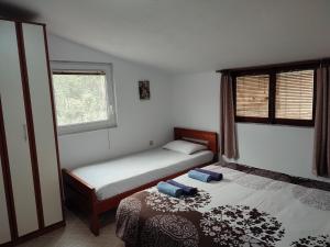 1 Schlafzimmer mit 2 Betten und einem Fenster in der Unterkunft Bay Mola Aparts in Kotor