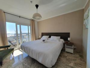 a bedroom with a large bed and a balcony at VISTAMALAGA in Málaga