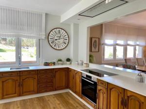 a large kitchen with a large clock on the wall at Casa do Rancho in Laxe