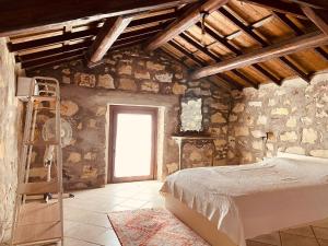 a bedroom with a bed in a stone wall at Casa di Pietra in San Giovanni Suèrgiu +48 photos