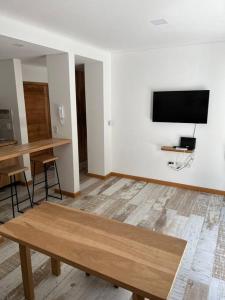 a living room with a table and a flat screen tv at Departamento 15 in Villa La Angostura