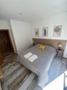 1 dormitorio con 1 cama con 2 toallas en Departamento 15 en Villa La Angostura