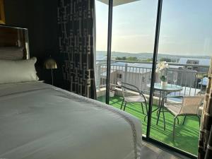 a bedroom with a bed and a balcony with a table at D&DLuxury Rivonia Apartments with inverter in Johannesburg
