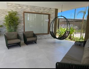 a patio with two chairs and a swing at Flat térreo e condomínio aconchegante ! in Recife