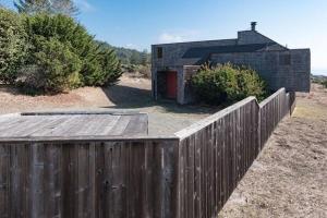 une clôture en bois devant un petit bâtiment dans l'établissement Holmes, à Sea Ranch