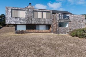 une maison en briques avec une grande cour dans l'établissement Holmes, à Sea Ranch