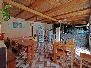 een restaurant met houten tafels en stoelen en een keuken bij Hostal Doña Clarita & Vegetarían Food in Chugchilán