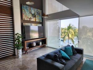 a living room with a couch and a flat screen tv at Lovely 4 bedroom penthouse Terra PH23 QueridaEstancia in Nuevo Vallarta