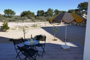 - une table et des chaises avec un parasol sur la plage dans l'établissement Apartmani Villa Ana, Sibenik - Brodarica, à Brodarica