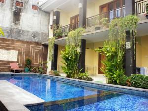 a swimming pool in the middle of a building at Waringin Homestay in Kuta