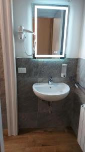 a bathroom with a sink and a mirror on the wall at Dépendance du Glam Resort in La Spezia