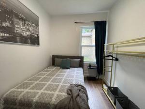a bedroom with a large bed and a window at Charming Century Apartments, Steps to downtown in London