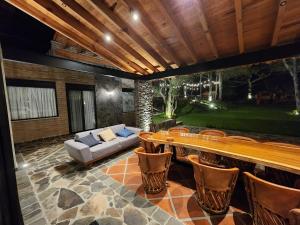 a patio with a couch and a table and chairs at Cabaña del Bosque Tapalpa Country Club L7M15 QueridaEstancia in Tapalpa