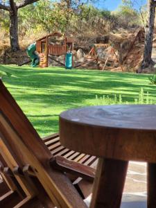 un banco de madera con una mesa y un parque infantil en Cabaña del Bosque Tapalpa Country Club L7M15 QueridaEstancia, en Tapalpa