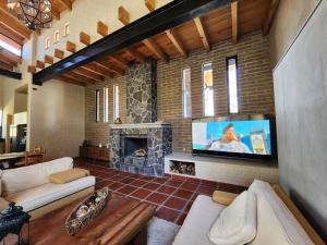 Una sala de estar con chimenea y televisión. en Cabaña del Bosque Tapalpa Country Club L7M15 QueridaEstancia, en Tapalpa