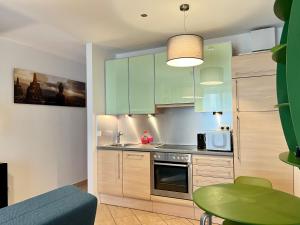una cocina con armarios verdes y una mesa verde en Feels-Like-Home Apt @ Praterstern en Viena