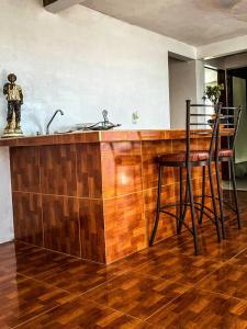 a kitchen with a wooden counter and a bar with stools at Departamento a 25 min del AIFA in Ecatepec