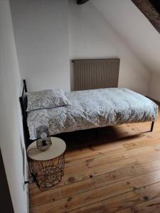 een slaapkamer met 2 bedden en een tafel op een houten vloer bij At Dream appartement in Bergues