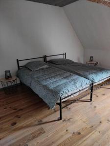 een bed in een kamer met een houten vloer bij At Dream appartement in Bergues