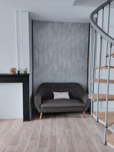 een woonkamer met een bank en een trap bij At Dream appartement in Bergues