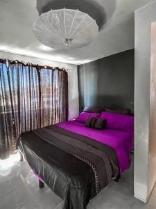 a bedroom with a large bed with purple sheets at Departamento a 25 min del AIFA in Ecatepec