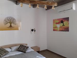 - une chambre avec un lit et un arbre sur le mur dans l'établissement Namastè, à Gasponi