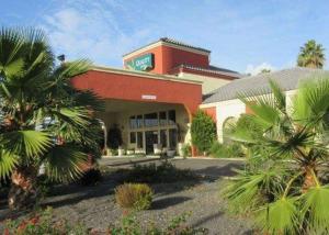 a building with a palm tree in front of it at Quality Inn Santa Nella on I-5 in Santa Nella Village
