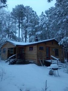 Cabaña de madera con nieve en el techo del bosque en Rustic Quaint Cabin In the woods--Pets welcomed, en Dunnsville