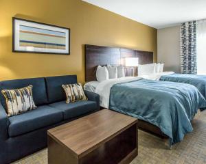 a hotel room with a bed and a couch at MainStay Suites Midland in Midland