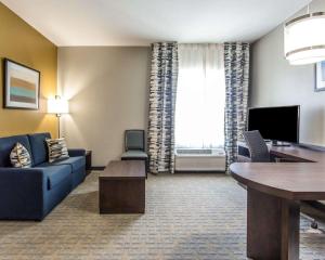 a living room with a couch and a desk in a hotel room at MainStay Suites Midland in Midland