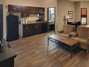 a living room with a couch and a table and a kitchen at Quality Inn & Suites Saskatoon in Saskatoon