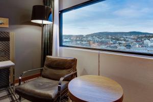krzesło i stół w pokoju z oknem w obiekcie Radisson Blu Scandinavia Hotel, Oslo w Oslo