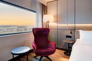 um quarto de hotel com uma cadeira vermelha e uma janela em Radisson Blu Scandinavia Hotel, Oslo em Oslo