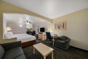 a hotel room with a bed and a living room at SureStay Hotel by Best Western Falfurrias in Falfurrias