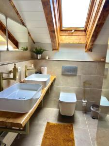 a bathroom with two sinks and a tub and a toilet at Gasthof Königstand in Garmisch-Partenkirchen