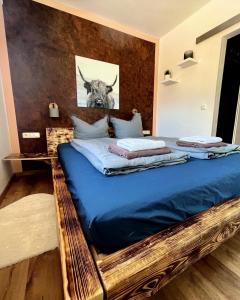 - une chambre avec un grand lit et une photo de taureau dans l'établissement Gasthof Königstand, à Garmisch-Partenkirchen
