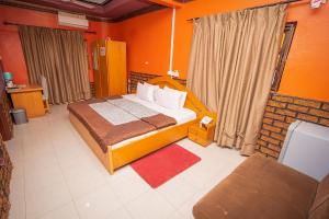 a bedroom with a bed in an orange room at Hilton View Hotel in Accra