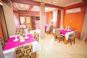 un comedor con mesas y sillas con mantel rosa en Hilton View Hotel, en Accra