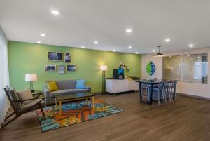 WoodSpring Suites Jacksonville Orange Park في أورانج بارك: غرفة معيشة مع أريكة وطاولة