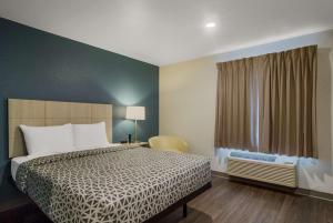 WoodSpring Suites Jacksonville Orange Park في أورانج بارك: غرفة نوم بسرير ونافذة