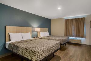 WoodSpring Suites Jacksonville Orange Park في أورانج بارك: غرفة فندقية بسريرين ونافذة