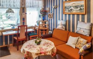 salon z pomarańczową kanapą i stołem w obiekcie 1 Bedroom Gorgeous Home In Loissin w mieście Loissin