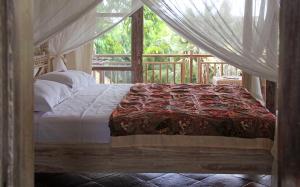 a bedroom with a bed with a canopy at Papaya Guesthouse in Canggu