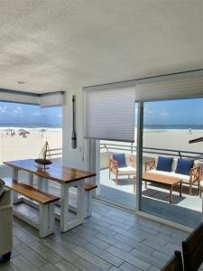 a living room with a table and a view of the beach at 125-fun In The Sun Penthouse in San Diego