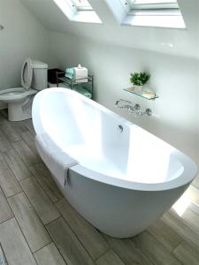 uma banheira branca na casa de banho com WC em 125-fun In The Sun Penthouse em San Diego