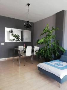 ein Wohnzimmer mit einem Tisch, Stühlen und einem Bett in der Unterkunft Apartamento para la felicidad in Roquetas de Mar