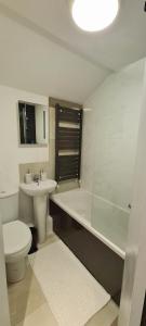 a bathroom with a toilet and a tub and a sink at Cosy flat - with excellent transport links in South Norwood