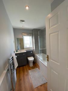 a bathroom with a toilet and a sink and a shower at Malmesbury 3 Bedroom Town House in Malmesbury
